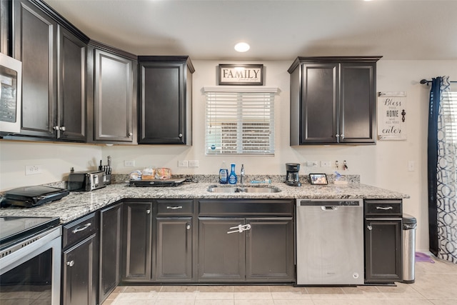 kitchen featuring light stone countertops, light tile patterned flooring, sink, and stainless steel appliances