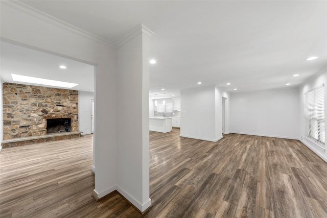 unfurnished living room with a fireplace, ornamental molding, and hardwood / wood-style flooring