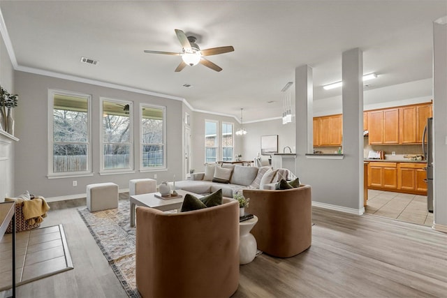 living room featuring crown molding, ceiling fan, and light wood-type flooring