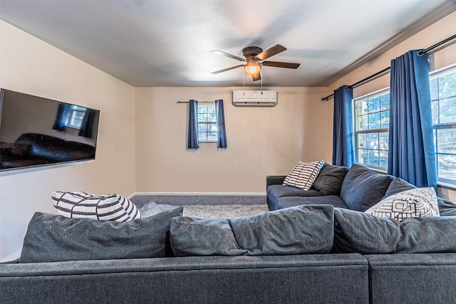 living room with baseboards, a ceiling fan, and a wall mounted air conditioner