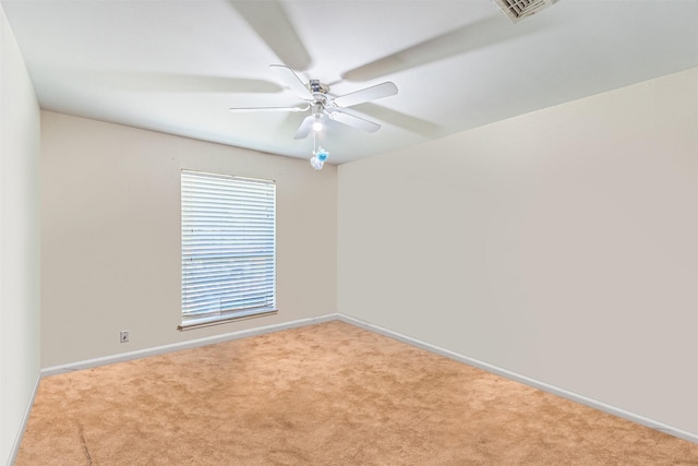 carpeted spare room with visible vents, ceiling fan, and baseboards