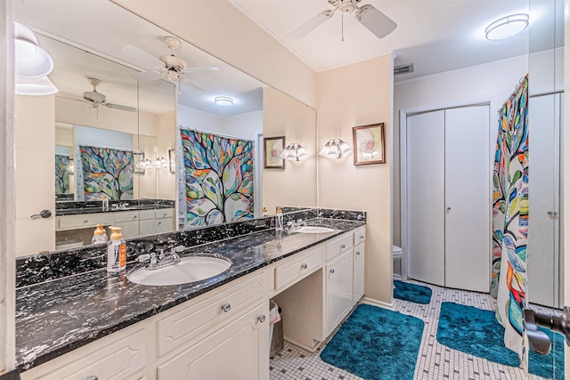 bathroom featuring a ceiling fan, a sink, and double vanity