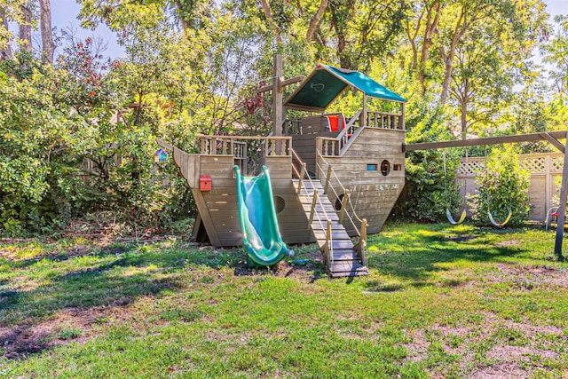 view of play area with fence and a yard