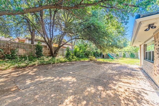 view of patio featuring a playground and a fenced backyard