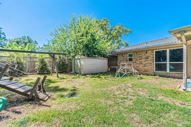 view of yard with a storage shed, an outbuilding, fence, central AC, and a playground