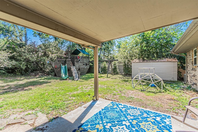 view of yard featuring a playground, a patio area, and a storage shed