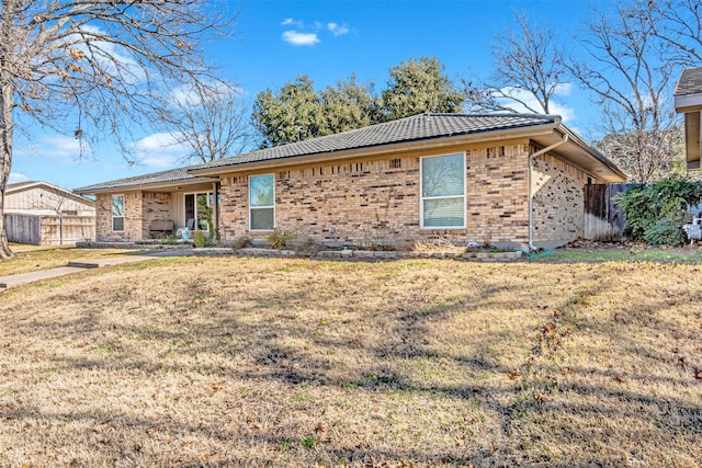 single story home featuring a front yard and brick siding