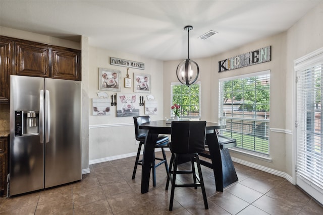 dining space featuring a chandelier and dark tile patterned floors