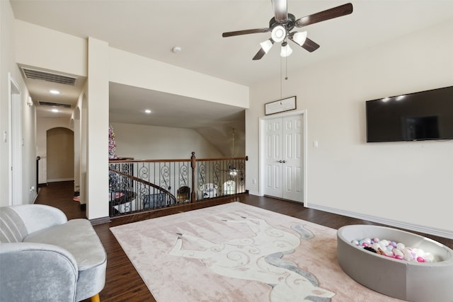 living room featuring ceiling fan and dark wood-type flooring