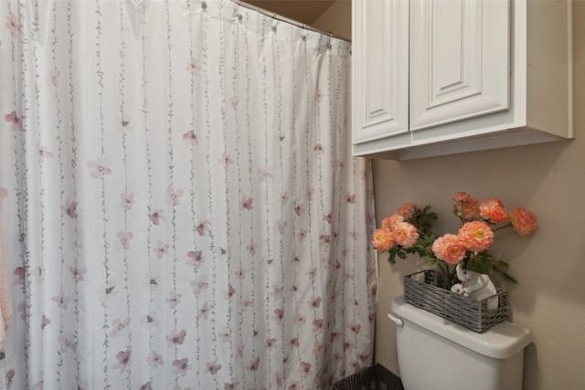 bathroom featuring walk in shower and toilet