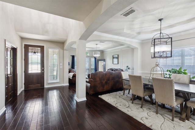 dining space featuring crown molding, plenty of natural light, dark wood-type flooring, and a chandelier