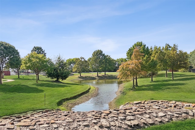 view of property's community with a yard and a water view