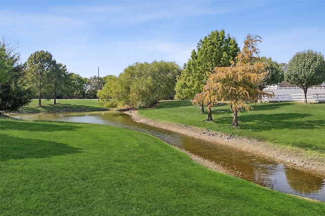 view of community featuring a water view and a yard