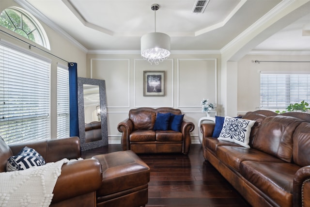 living room featuring crown molding, a raised ceiling, and dark hardwood / wood-style flooring