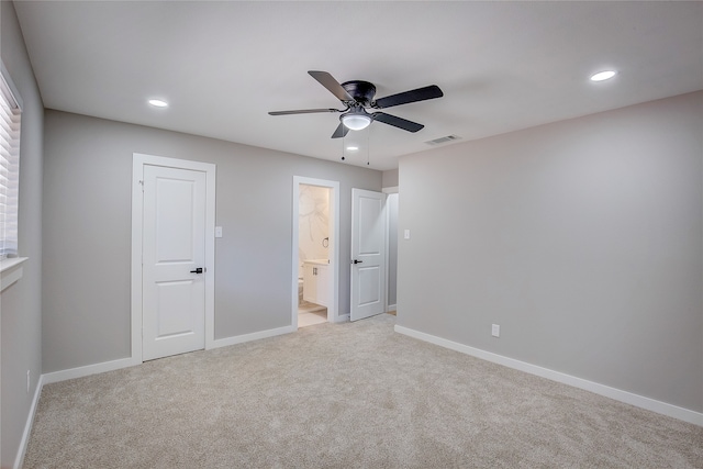 unfurnished bedroom featuring connected bathroom, ceiling fan, and light carpet