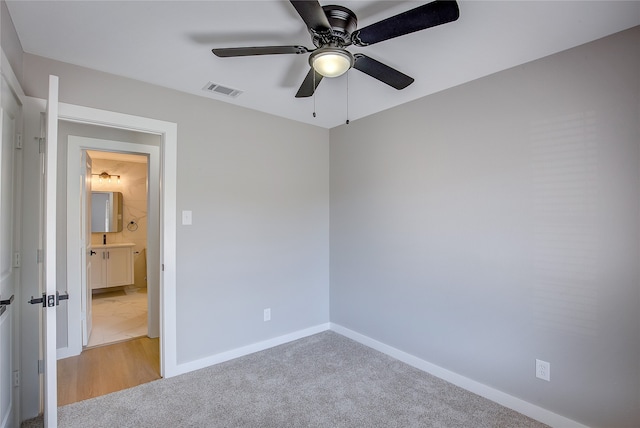 empty room with ceiling fan and light colored carpet