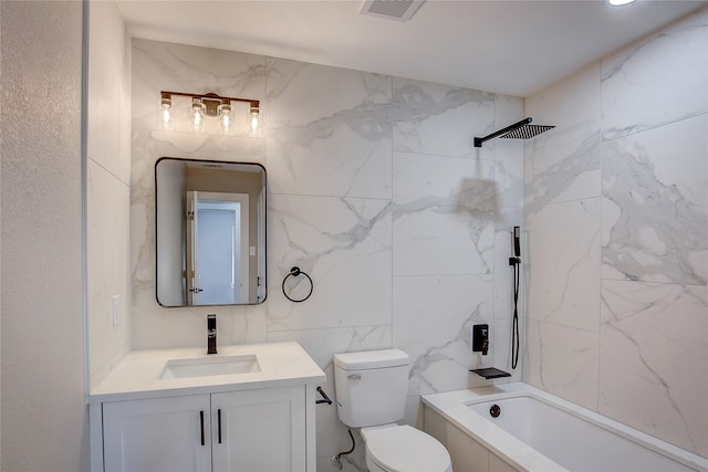 full bathroom featuring toilet, vanity, tile walls, and tiled shower / bath