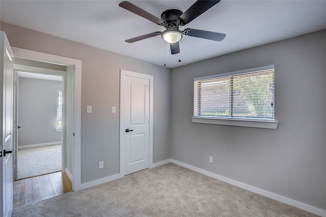 unfurnished bedroom with ceiling fan, a closet, and light carpet