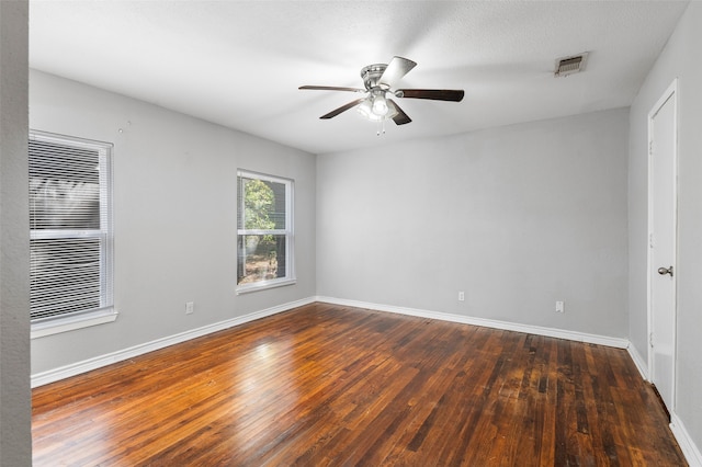 unfurnished room with ceiling fan, dark wood-type flooring, and a textured ceiling