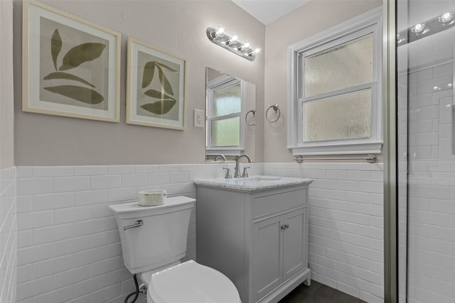 bathroom featuring vanity, toilet, and tile walls