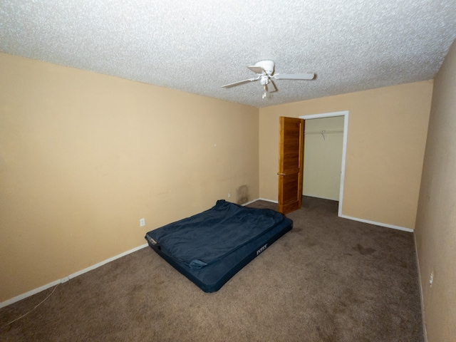 carpeted bedroom with a textured ceiling, ceiling fan, and a closet