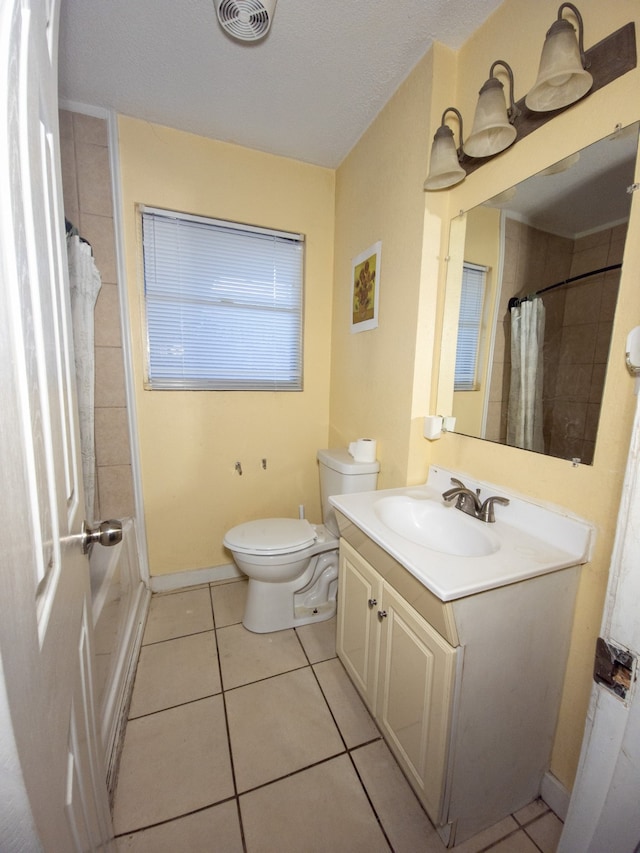 bathroom featuring a textured ceiling, vanity, toilet, and tile patterned floors