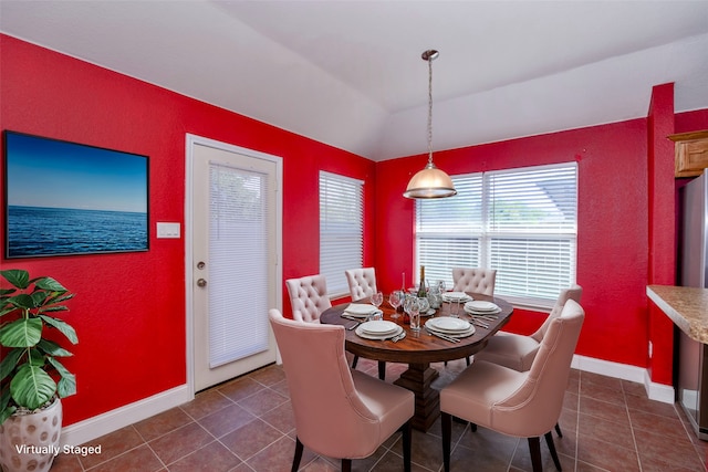 tiled dining room featuring lofted ceiling