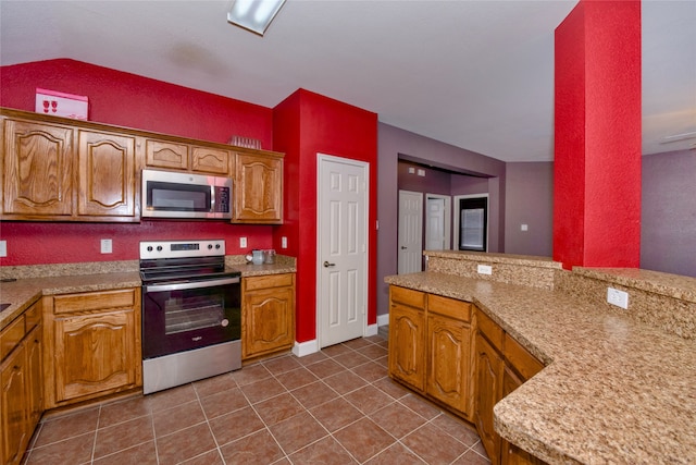 kitchen featuring dark tile patterned flooring and appliances with stainless steel finishes