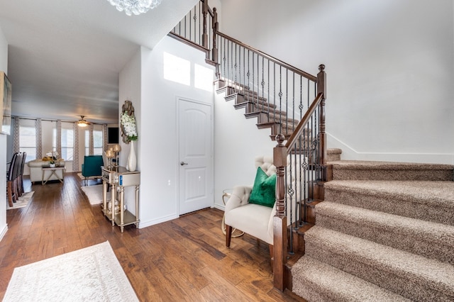 staircase featuring hardwood / wood-style floors and ceiling fan