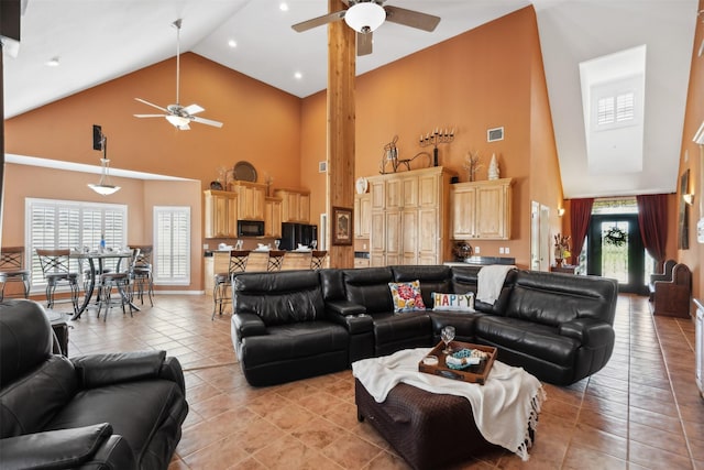 living area featuring a ceiling fan, high vaulted ceiling, visible vents, and light tile patterned floors