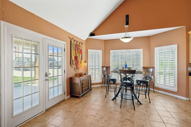 dining room with light tile patterned flooring, high vaulted ceiling, and french doors