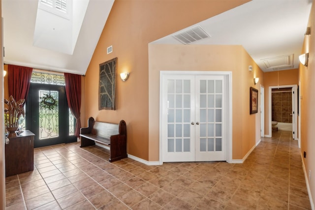 tiled foyer with french doors and lofted ceiling