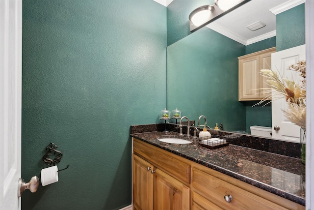 bathroom featuring crown molding, vanity, a textured wall, and toilet