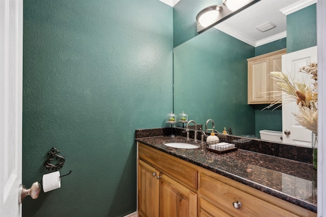 bathroom with vanity, toilet, and crown molding