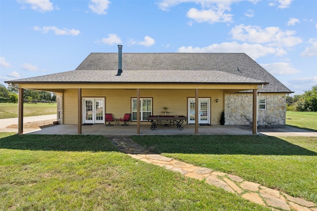 back of property with a lawn, french doors, and a patio