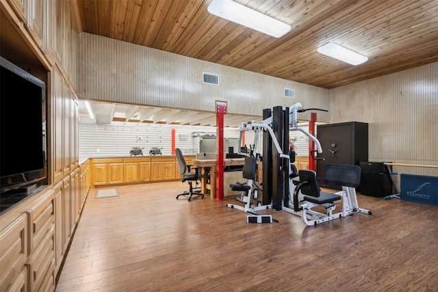 workout area featuring wood walls, light wood-type flooring, and wooden ceiling