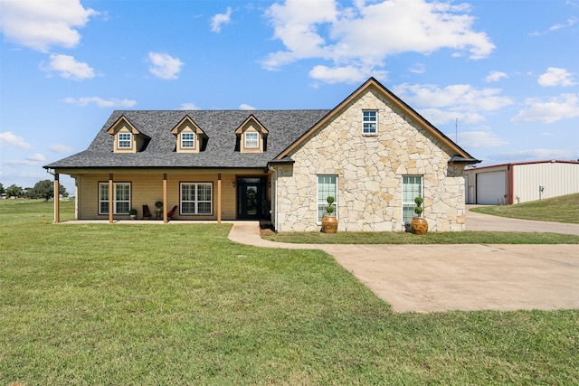 view of front of property with a garage, an outbuilding, and a front yard