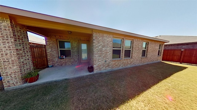 back of house featuring a lawn and a patio area