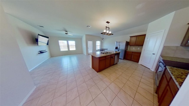 kitchen with a center island, stainless steel fridge with ice dispenser, stove, hanging light fixtures, and ceiling fan