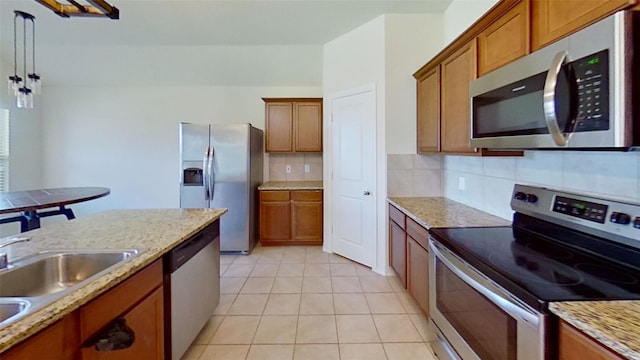 kitchen with sink, backsplash, appliances with stainless steel finishes, light tile patterned floors, and decorative light fixtures