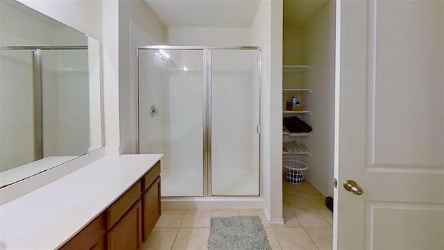 bathroom featuring tile patterned floors, a shower with door, and vanity