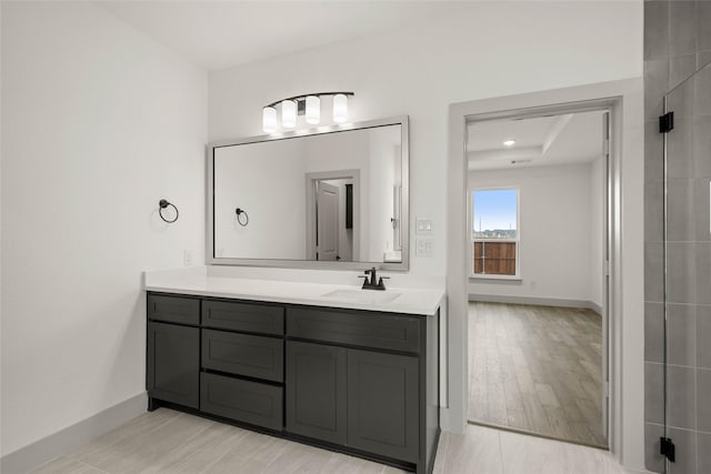 full bathroom featuring baseboards, wood finished floors, and vanity