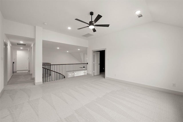 empty room featuring lofted ceiling, recessed lighting, baseboards, and light colored carpet