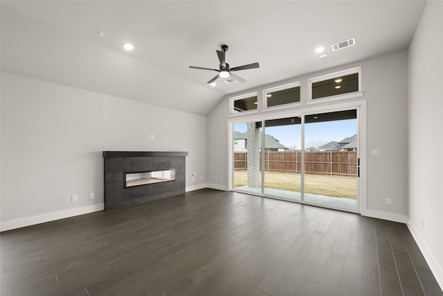 unfurnished living room featuring ceiling fan, dark wood-type flooring, lofted ceiling, and a fireplace