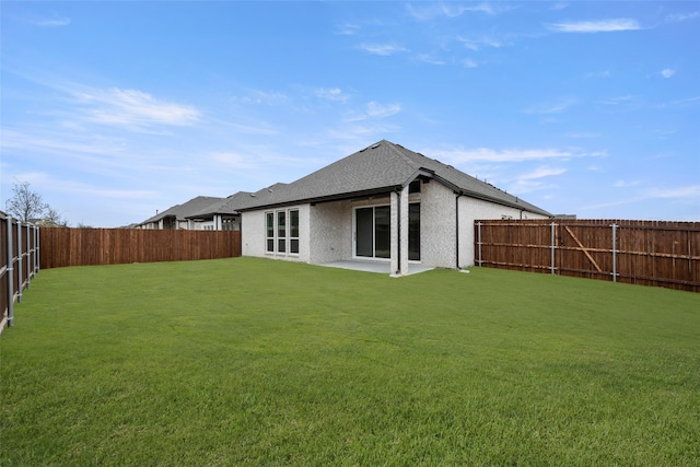 rear view of property featuring a lawn and a patio