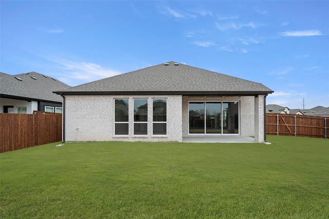 rear view of property featuring a lawn