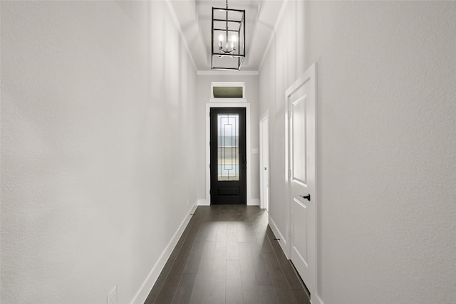 doorway to outside with crown molding, a chandelier, a high ceiling, and dark hardwood / wood-style flooring