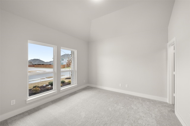 carpeted spare room with lofted ceiling