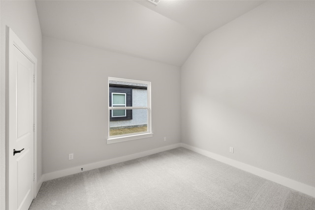 empty room featuring carpet floors and lofted ceiling