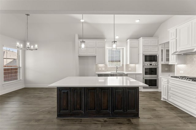 kitchen with decorative light fixtures, a kitchen island, and tasteful backsplash